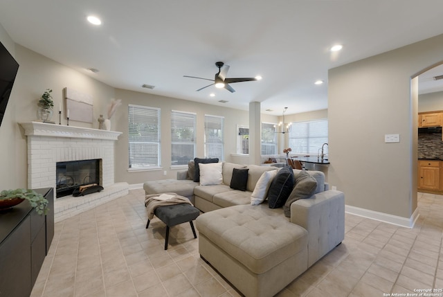 21731 Cliff Vw, San Antonio, TX 78259 - living room featuring ceiling fan, a fireplace, recessed lighting, light tile patterned flooring, and a chandelier