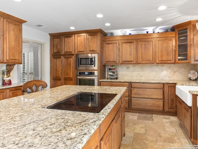16018 Alsace, San Antonio, TX 78232 - kitchen with appliances with stainless steel finishes, recessed lighting, light stone counters, and brown cabinets