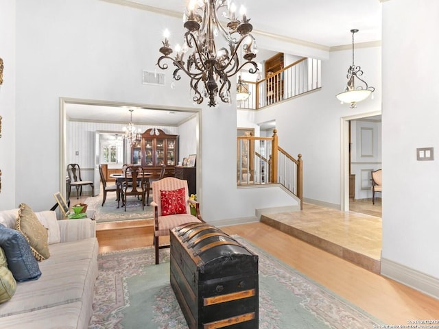 16018 Alsace, San Antonio, TX 78232 - living room featuring a chandelier, stairs, wood finished floors, a towering ceiling, and ornamental molding