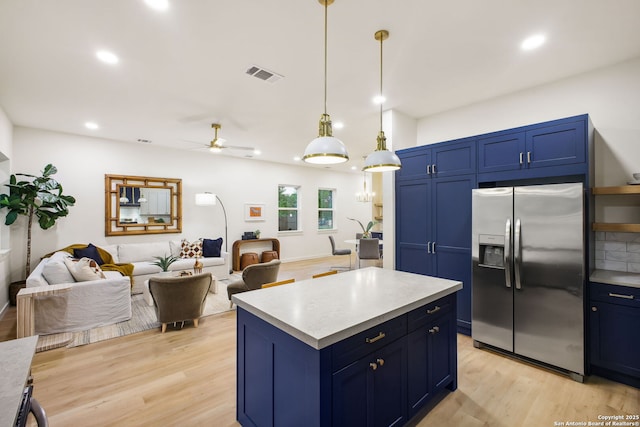 1939 W French Pl, San Antonio, TX 78201 - kitchen featuring stainless steel fridge with ice dispenser, blue cabinets, light wood-style flooring, light countertops, and recessed lighting