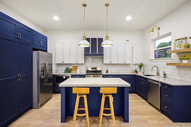 1939 W French Pl, San Antonio, TX 78201 - kitchen with stainless steel appliances, blue cabinets, a center island, a kitchen bar, and light countertops