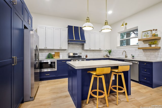1939 W French Pl, San Antonio, TX 78201 - kitchen with stainless steel appliances, blue cabinetry, custom exhaust hood, a kitchen bar, and recessed lighting