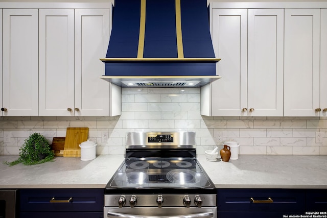 1939 W French Pl, San Antonio, TX 78201 - kitchen featuring stainless steel electric stove, premium range hood, blue cabinetry, and backsplash
