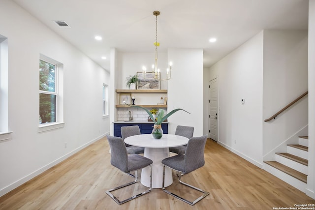 1939 W French Pl, San Antonio, TX 78201 - dining area with a chandelier, light wood finished floors, stairway, and recessed lighting