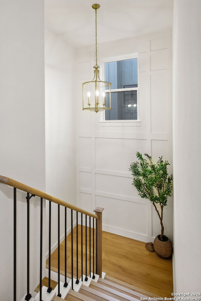 1939 W French Pl, San Antonio, TX 78201 - stairs featuring wood finished floors, a chandelier, and a decorative wall