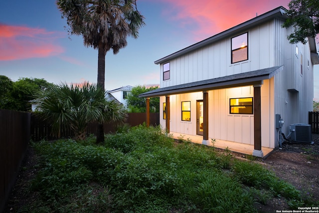 1939 W French Pl, San Antonio, TX 78201 - back of house at dusk with board and batten siding and a fenced backyard