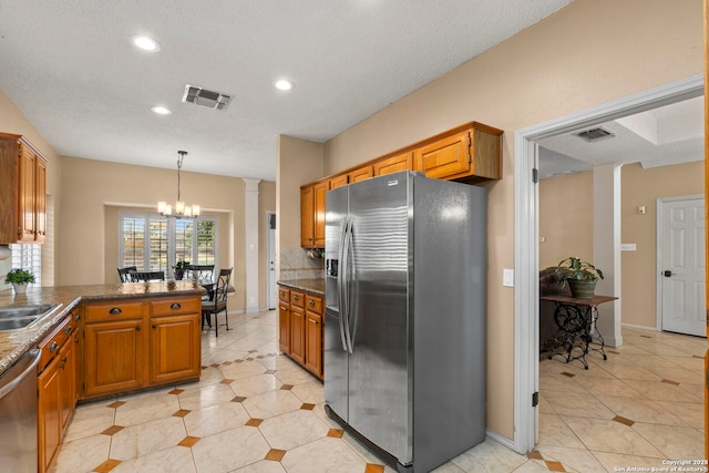19502 Encino Bow, San Antonio, TX 78259 - kitchen featuring appliances with stainless steel finishes, decorative columns, a chandelier, light tile patterned floors, and dark countertops