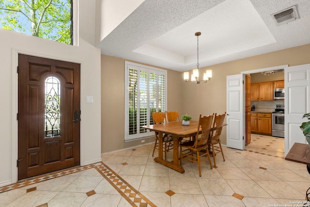 19502 Encino Bow, San Antonio, TX 78259 - dining space with a chandelier, light tile patterned floors, a raised ceiling, and a textured ceiling