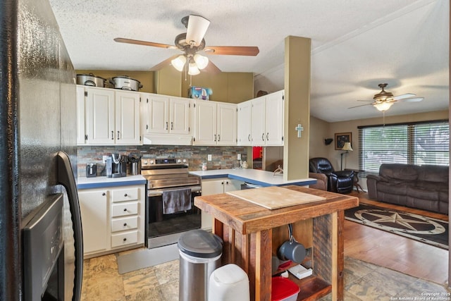 1111 Valeria, Marion, TX 78124 - kitchen with stainless steel range with electric cooktop, ceiling fan, under cabinet range hood, black refrigerator with ice dispenser, and decorative backsplash