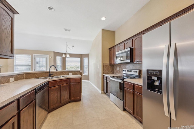 7738 Brisbane Bnd, Converse, TX 78109 - kitchen featuring stainless steel appliances, vaulted ceiling, tasteful backsplash, light countertops, and recessed lighting