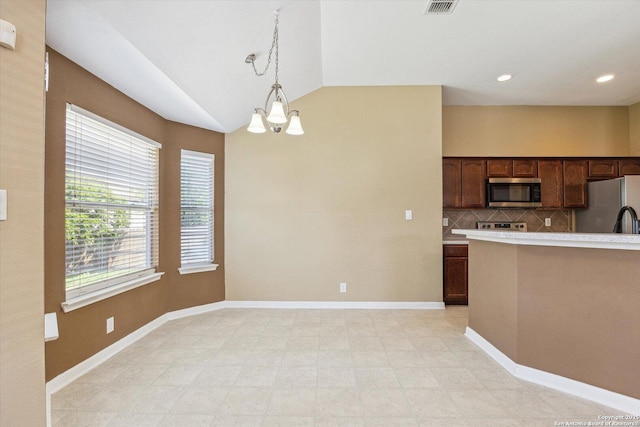 7738 Brisbane Bnd, Converse, TX 78109 - kitchen with appliances with stainless steel finishes, vaulted ceiling, light countertops, decorative light fixtures, and backsplash
