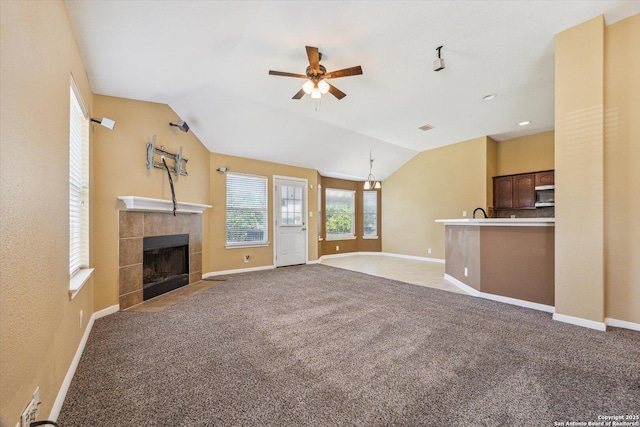 7738 Brisbane Bnd, Converse, TX 78109 - unfurnished living room with ceiling fan, lofted ceiling, a tiled fireplace, and carpet