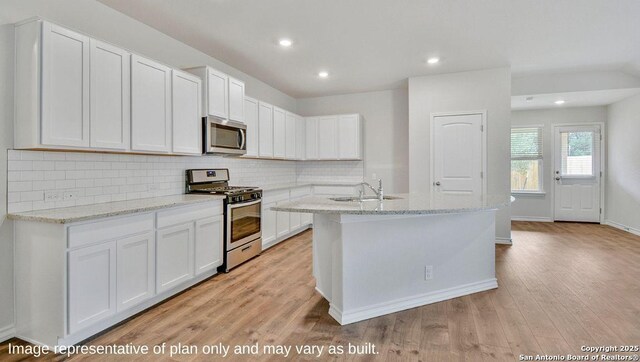 14807 Hooded Merganser, San Antonio, TX 78253 - kitchen with appliances with stainless steel finishes, decorative backsplash, light wood-type flooring, white cabinets, and recessed lighting