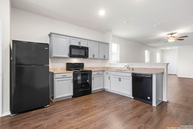 759 Crested Iris, New Braunfels, TX 78130 - kitchen with black appliances, a peninsula, ceiling fan, dark wood-style floors, and light stone countertops