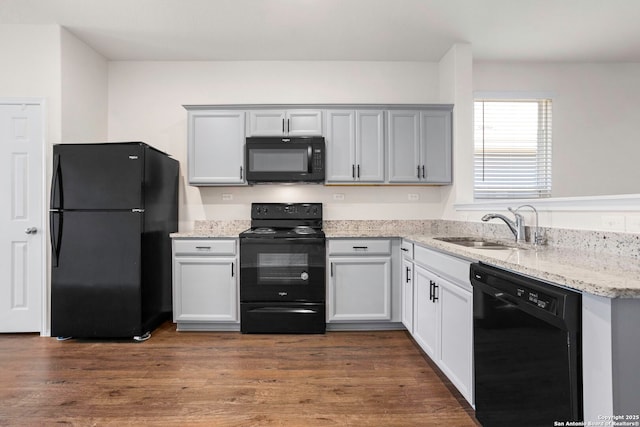 759 Crested Iris, New Braunfels, TX 78130 - kitchen with black appliances, light stone countertops, and dark wood-type flooring