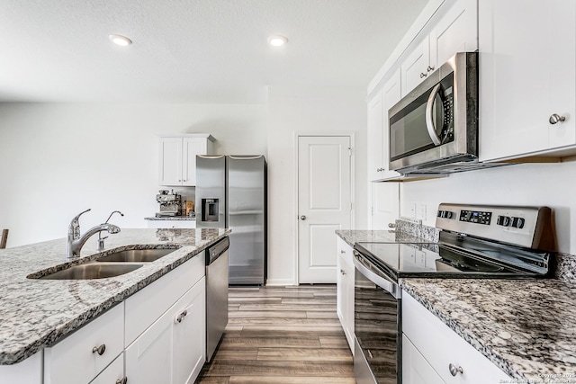 5323 Flying Hooves, San Antonio, TX 78222 - kitchen featuring stainless steel appliances, light stone counters, white cabinets, light wood-type flooring, and recessed lighting
