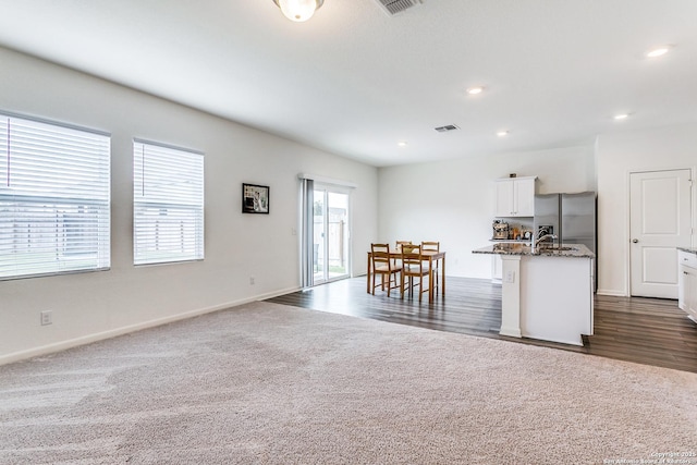 5323 Flying Hooves, San Antonio, TX 78222 - kitchen with stainless steel fridge with ice dispenser, dark stone counters, white cabinetry, recessed lighting, and open floor plan