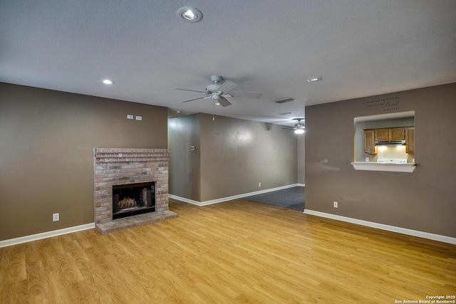 15306 Spring Dew, San Antonio, TX 78247 - unfurnished living room with a ceiling fan, a fireplace, light wood-type flooring, and recessed lighting