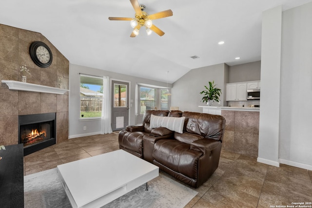 9511 Autumn Run, Converse, TX 78109 - tiled living area with vaulted ceiling, ceiling fan, a tiled fireplace, and recessed lighting