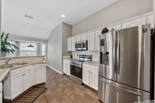 9511 Autumn Run, Converse, TX 78109 - kitchen featuring stainless steel appliances, decorative backsplash, lofted ceiling, white cabinets, and light countertops