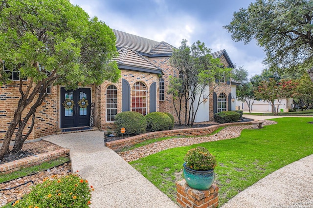 342 Candelaria, Helotes, TX 78023 - view of front of property featuring french doors, brick siding, and a front lawn