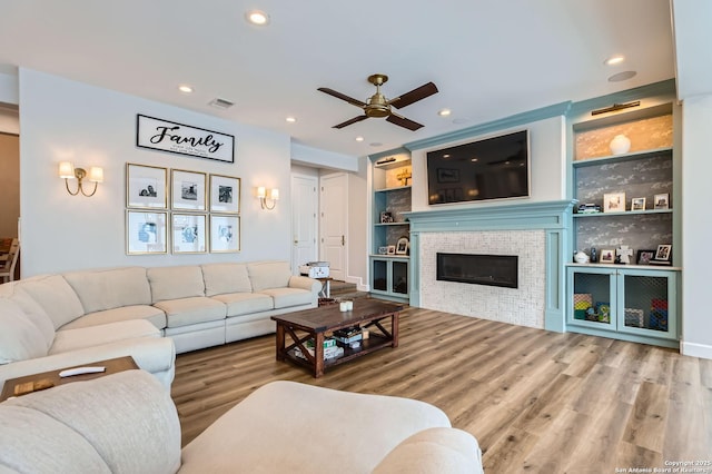 342 Candelaria, Helotes, TX 78023 - living area featuring ceiling fan, built in features, wood finished floors, recessed lighting, and a tiled fireplace
