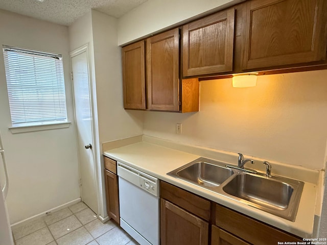13018 Heimer Unit 805, San Antonio, TX 78216 - kitchen featuring white dishwasher, light countertops, light tile patterned floors, brown cabinetry, and a textured ceiling