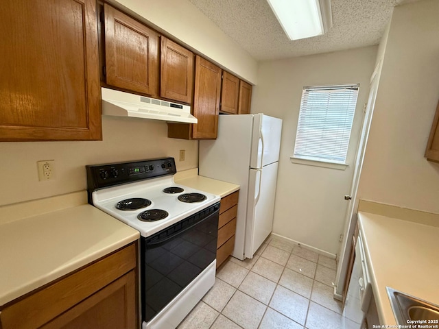 13018 Heimer Unit 805, San Antonio, TX 78216 - kitchen with electric range oven, under cabinet range hood, brown cabinetry, light tile patterned floors, and light countertops