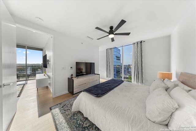 313 17th Unit, Austin, TX 78701 - bedroom with light wood-type flooring, access to exterior, and ceiling fan