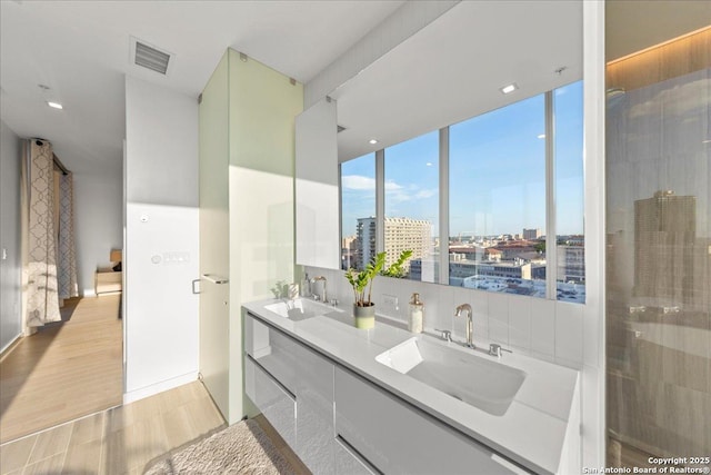 313 17th Unit, Austin, TX 78701 - full bathroom featuring double vanity, a view of city, and wood finished floors