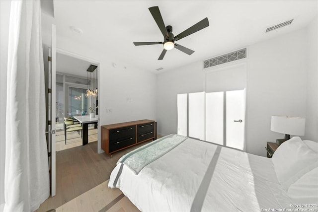 313 17th Unit, Austin, TX 78701 - bedroom with wood finished floors, a chandelier, and ceiling fan