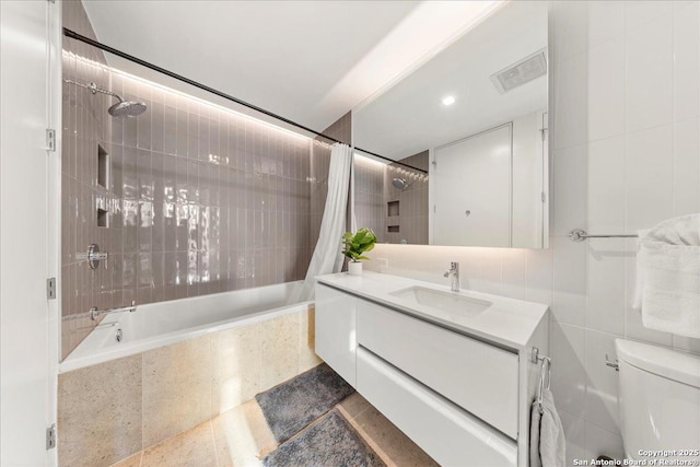 313 17th Unit, Austin, TX 78701 - bathroom featuring tiled shower / bath, vanity, and tile walls