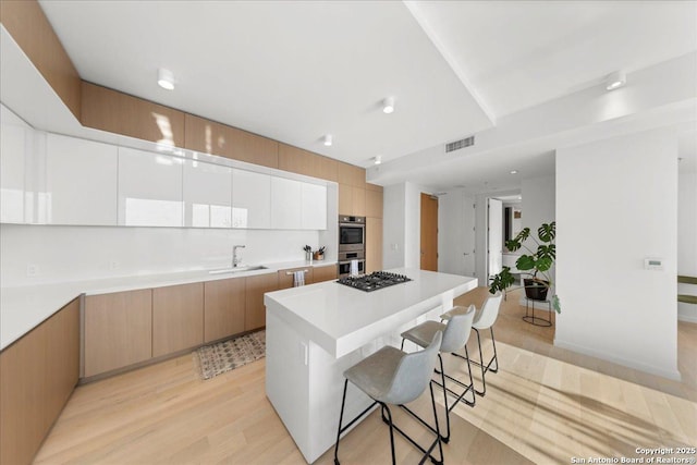313 17th Unit, Austin, TX 78701 - kitchen with a breakfast bar, modern cabinets, a center island, and stainless steel appliances