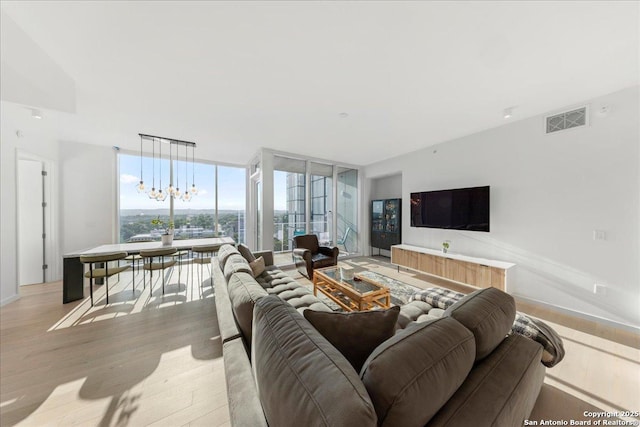 313 17th Unit, Austin, TX 78701 - living room featuring a chandelier, light wood-style floors, and a wall of windows