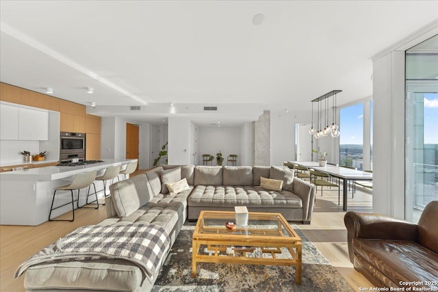 313 17th Unit, Austin, TX 78701 - living area featuring light wood-style floors and a chandelier