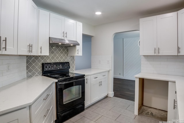7711 Chatsworth, San Antonio, TX 78250 - kitchen with black electric range oven, under cabinet range hood, light countertops, light tile patterned flooring, and white cabinets
