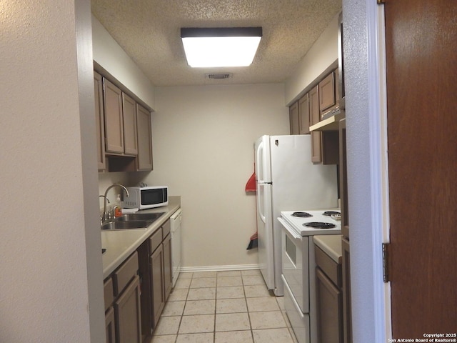 4119 Medical Unit 304F, San Antonio, TX 78229 - kitchen with white appliances, a textured ceiling, light countertops, light tile patterned floors, and under cabinet range hood