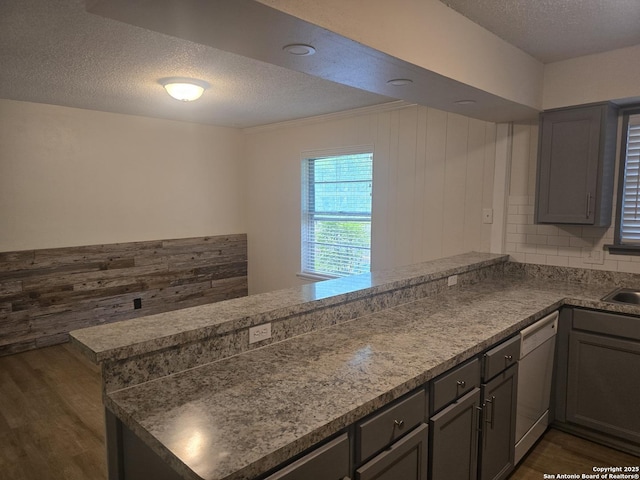 5214 King George, San Antonio, TX 78229 - kitchen featuring dishwasher, dark wood-type flooring, a textured ceiling, a peninsula, and gray cabinetry