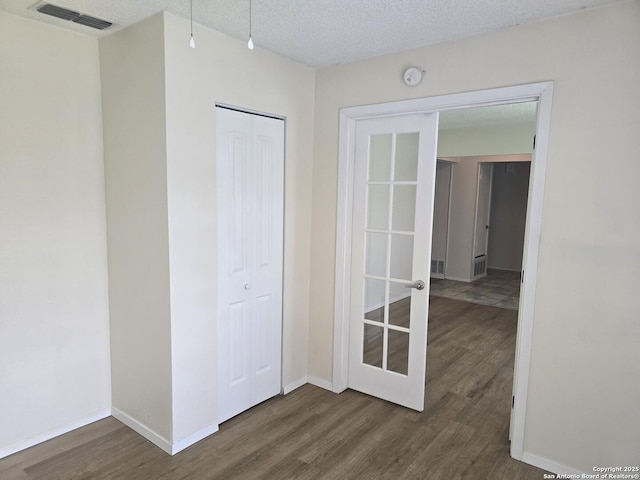 5214 King George, San Antonio, TX 78229 - unfurnished room featuring wood finished floors, a textured ceiling, and a smoke detector