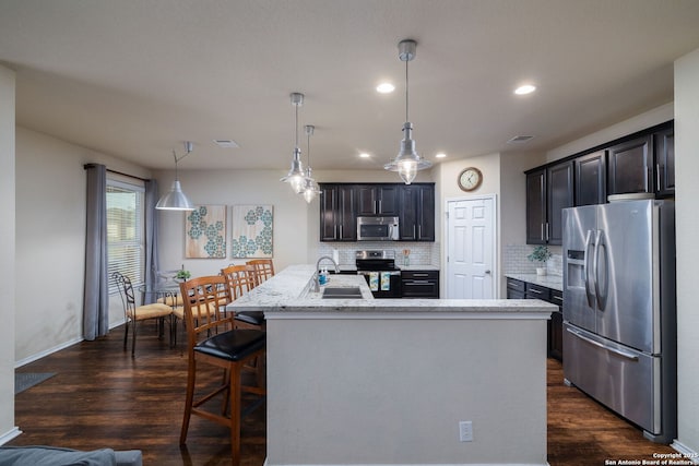 401 Canterbury, Cibolo, TX 78108 - kitchen with stainless steel appliances, decorative backsplash, an island with sink, dark wood-type flooring, and recessed lighting