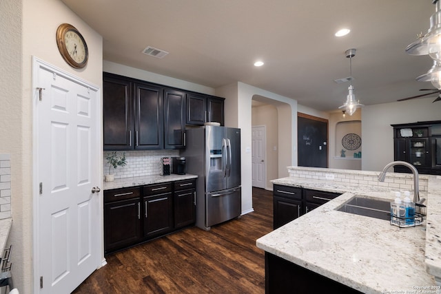 401 Canterbury, Cibolo, TX 78108 - kitchen with stainless steel fridge, arched walkways, dark wood-style flooring, backsplash, and light stone counters