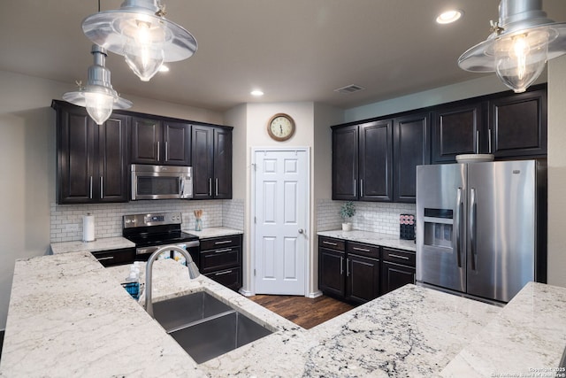 401 Canterbury, Cibolo, TX 78108 - kitchen with stainless steel appliances, light stone counters, dark wood-style floors, backsplash, and decorative light fixtures
