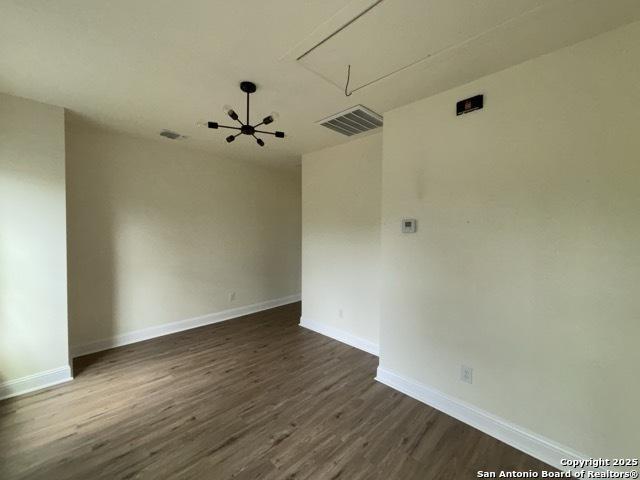 1014 Montana, San Antonio, TX 78203 - unfurnished room featuring attic access and dark wood-type flooring
