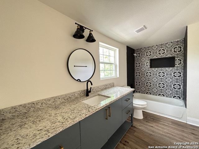 1014 Montana, San Antonio, TX 78203 - full bathroom featuring vanity, wood finished floors, and bathing tub / shower combination