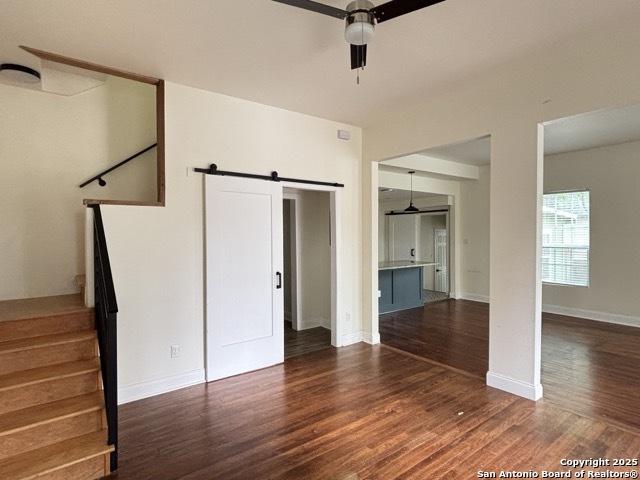 1014 Montana, San Antonio, TX 78203 - spare room featuring a ceiling fan, wood finished floors, a barn door, and stairway