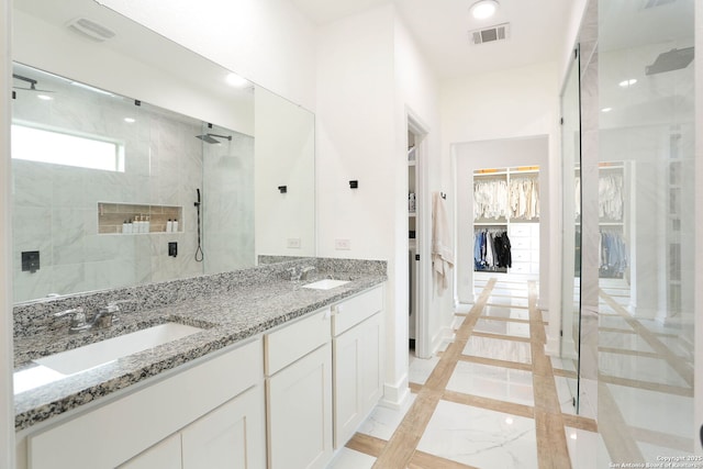 2863 Tortuga Verde, San Antonio, TX 78245 - bathroom featuring a tile shower, double vanity, a spacious closet, inlaid floor details, and marble finish floors