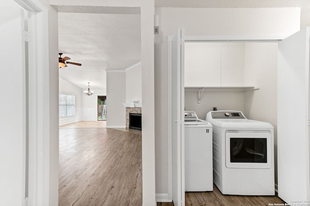 3410 Lone Valley St, San Antonio, TX 78247 - washroom featuring separate washer and dryer, wood finished floors, a chandelier, a ceiling fan, and a fireplace