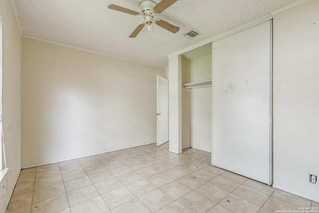 14410 Briarberry, San Antonio, TX 78247 - unfurnished bedroom with a textured ceiling, light tile patterned floors, a closet, and ceiling fan