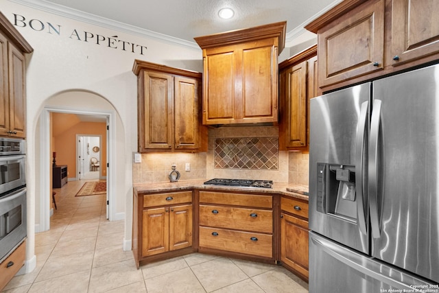 106 Oak Meadow Ln, Boerne, TX 78006 - kitchen featuring stainless steel appliances, crown molding, light stone countertops, backsplash, and light tile patterned flooring