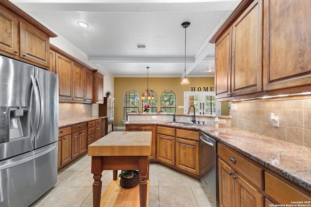 106 Oak Meadow Ln, Boerne, TX 78006 - kitchen with stainless steel appliances, brown cabinets, backsplash, a peninsula, and crown molding